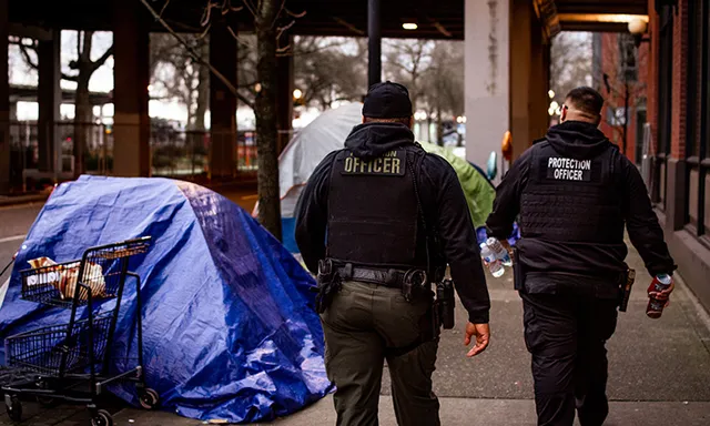 Two uniformed security officers walking down a city sidewalk